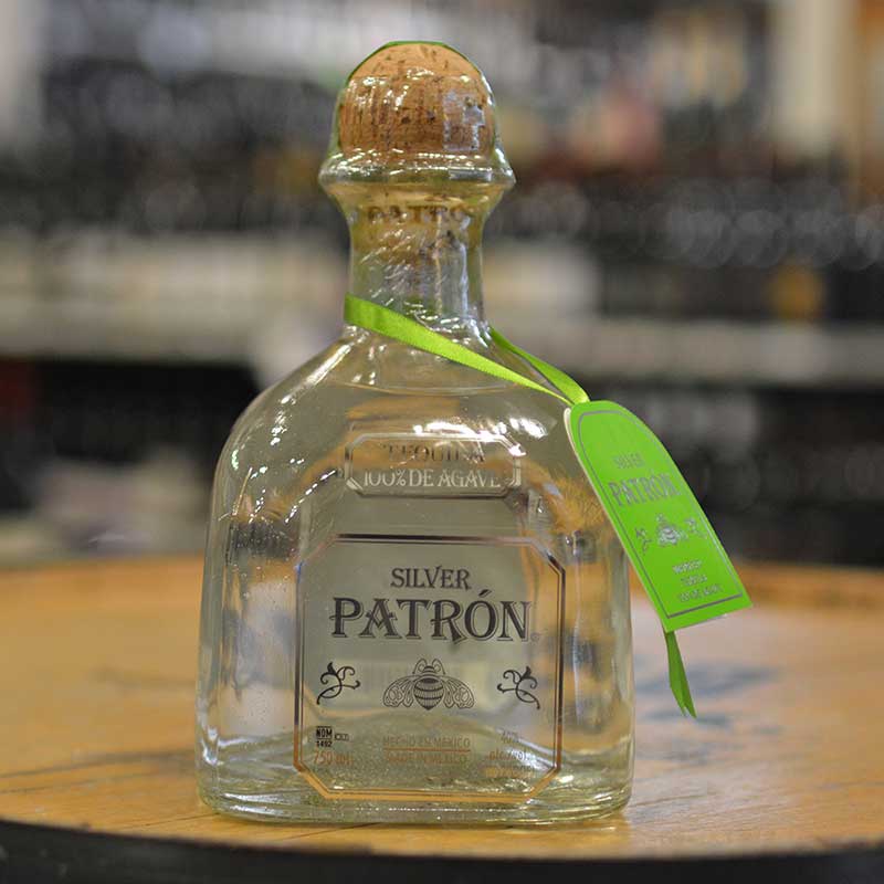 Bottle of tequila sitting on a barrel head at Hickey's Wine & Spirits.