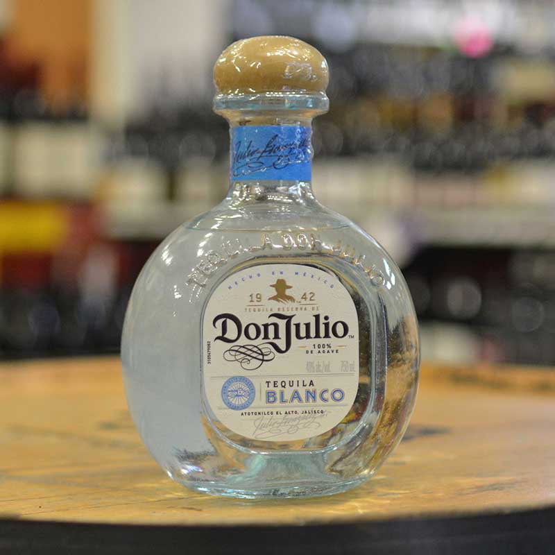 Bottle of tequila blanco sitting on a barrel head at Hickey's Wine & Spirits.