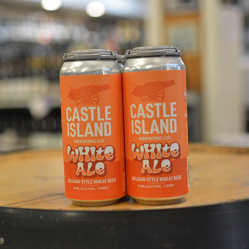 Four-pack of Belgian-style wheat beer sitting on a barrel head at Hickey's Wine & Spirits.