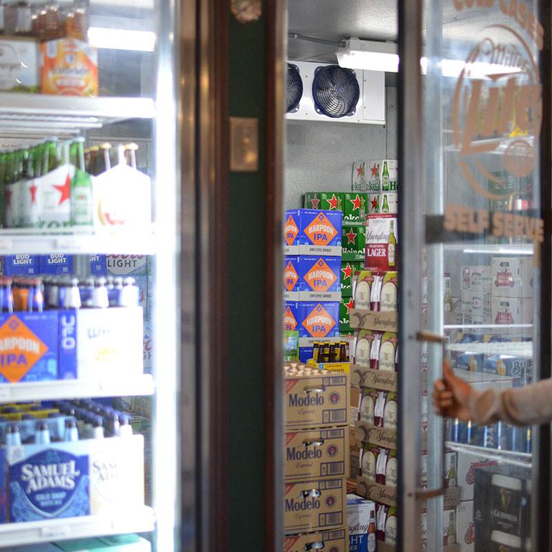 A selection of beers behind in coolers and walk-in coolers at Hickey's Wine & Spirits.