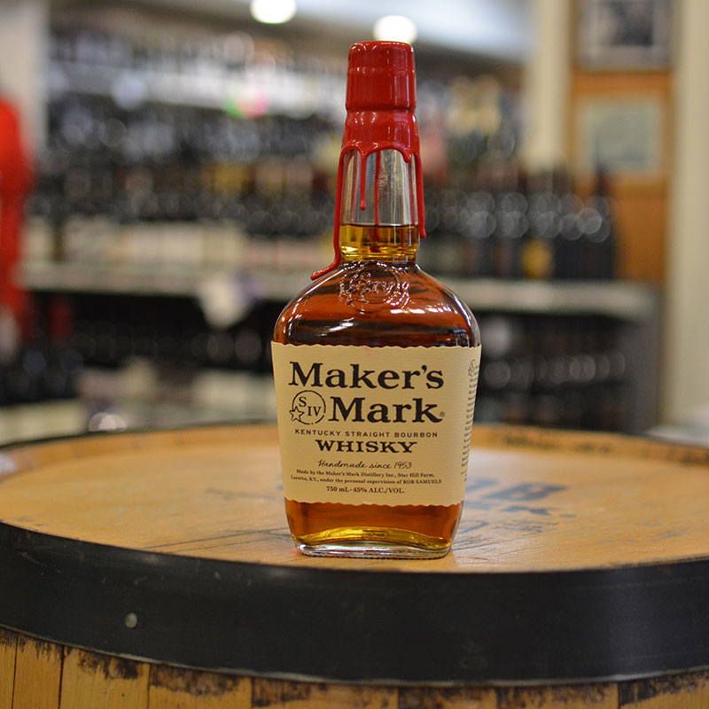 Bottle of Kentucky bourbon sitting on a barrel head at Hickey's Wine & Spirits.